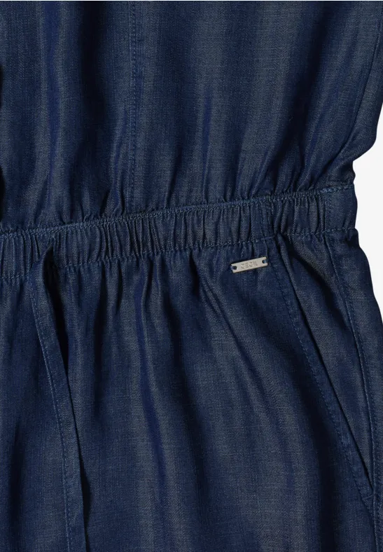 Nahaufnahme eines dunkelblauen Denim-Jumpsuits mit elastischer Taille und Taschen.