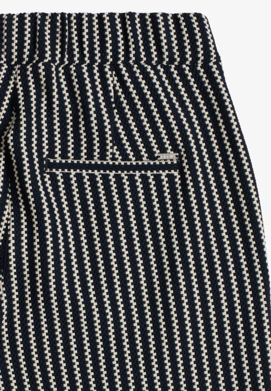 Schwarz-weiße Hose mit Zickzackstreifen und einer kontrastierenden Gesäßtasche.
