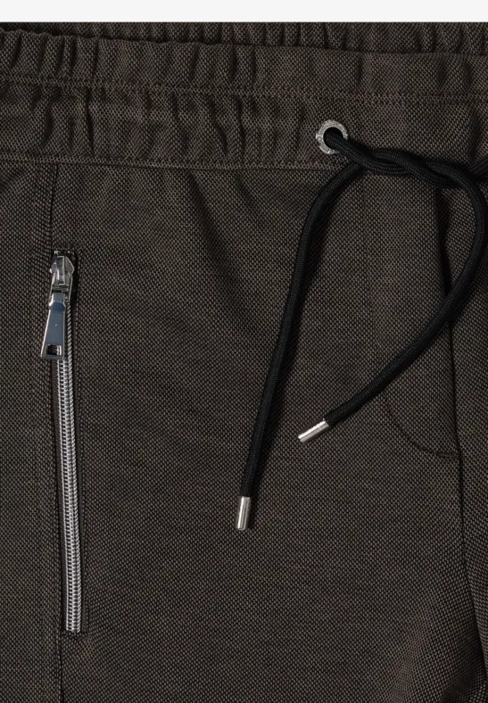 Dunkelgraue Jogginghose mit elastischem Bund, schwarzem Kordelzug und Reißverschlusstasche an der Seite.