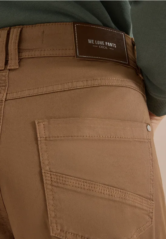 Nahaufnahme einer Person in braunen Jeans mit einer Gesäßtasche und Label "We Love Pants".