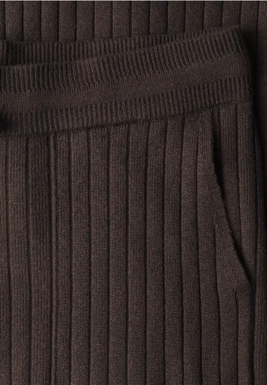 Gros plan sur un tissu tricoté marron côtelé avec ceinture élastique et poche latérale.