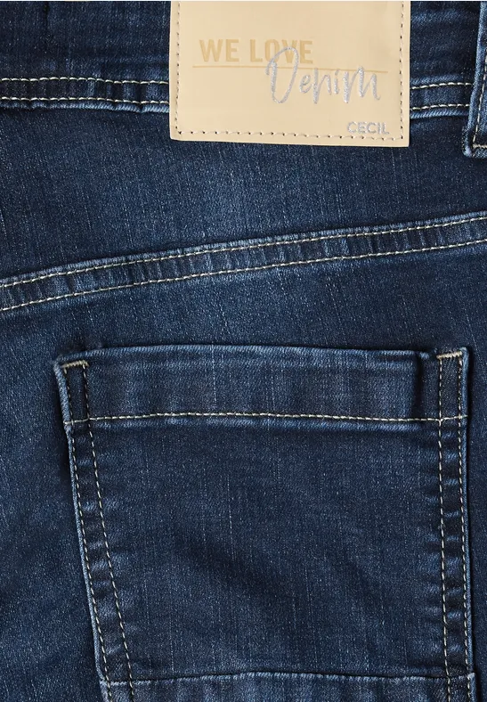 Nahaufnahme einer dunkelblauen Jeans mit Seitentasche und Lederetikett 'WE LOVE Denim'.