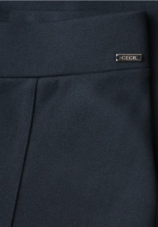 Gros plan sur un vêtement bleu foncé avec une large ceinture et une petite étiquette métallique