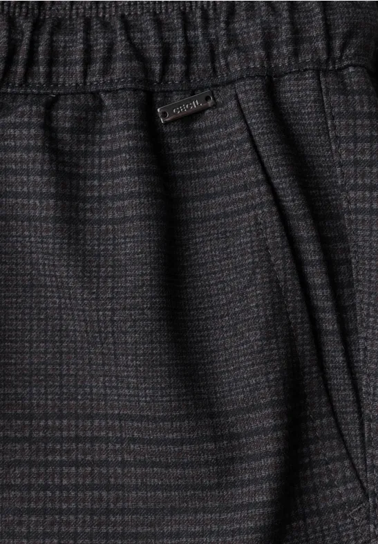 Detailaufnahme einer dunkelgrauen, gemusterten Hose mit elastischem Bund und seitlicher Tasche.