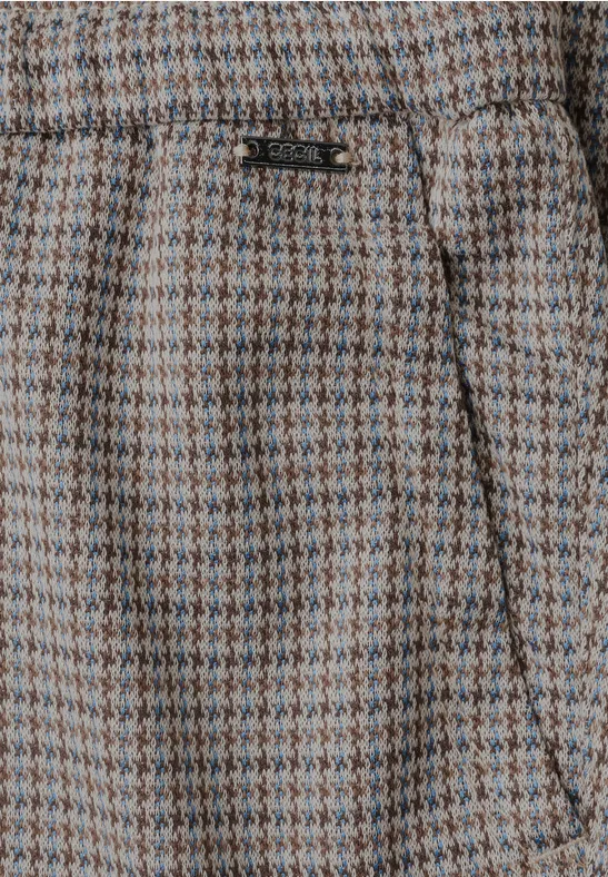Nahaufnahme einer beige-grünen Hahnentrittmuster-Hose mit seitlicher Tasche.