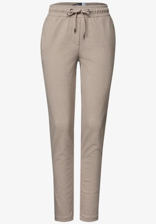 Enganliegende, bequeme Sweatpants in Beige mit Tunnelzug an der Taille und schmal zulaufenden Beinen.