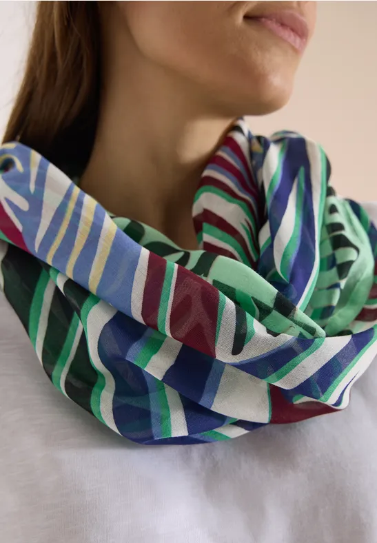 Eine Frau trägt einen bunt gestreiften Loop-Schal um den Hals.
