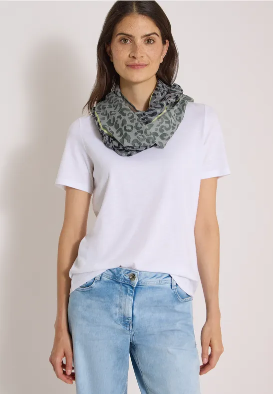 Frau in weißem T-Shirt, blauen Jeans und gemustertem Schal.