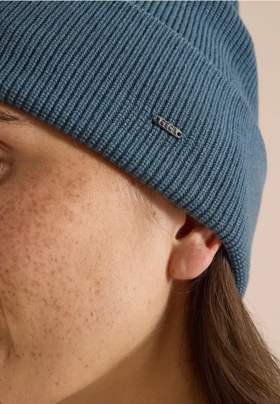 Profil latéral d'une personne aux taches de rousseur portant un bonnet bleu