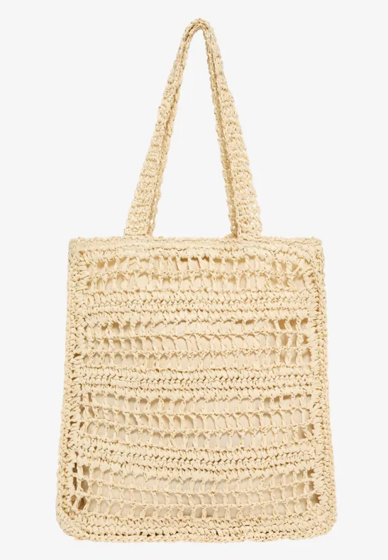 Eine beige gehäkelte Stroh-Tasche mit langen Henkeln, rechteckig und luftig gewebt.