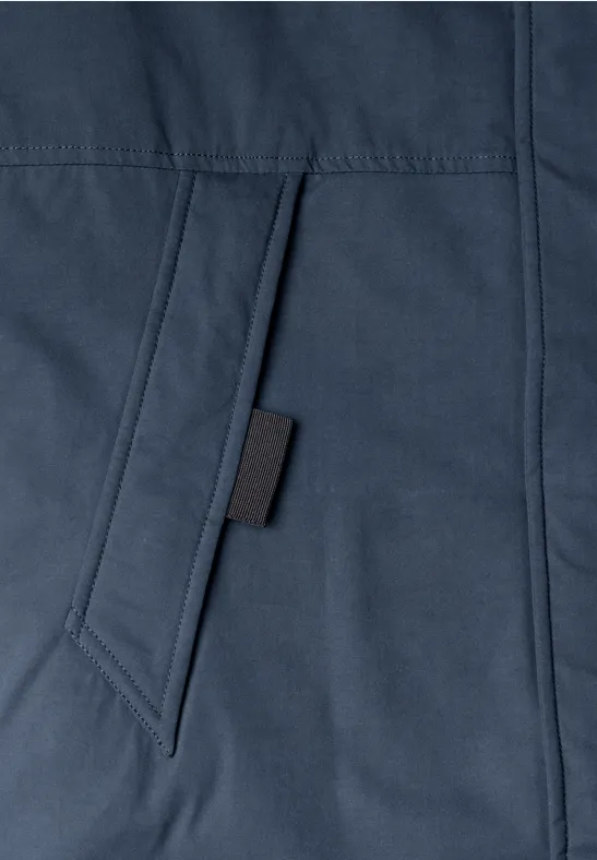 Nahaufnahme einer dunkelblauen Jackentasche mit schwarzem Tab