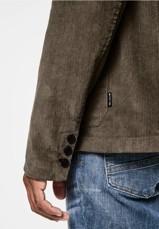 Man met corduroy jasje en spijkerbroek.