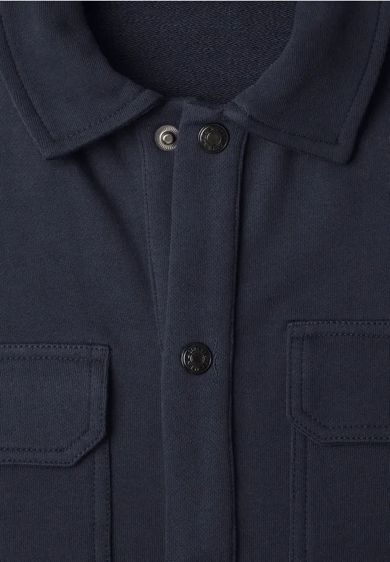 Marineblaue Jacke mit Hemdkragen, zwei Brusttaschen mit Klappen und durchgehender Knopfleiste.