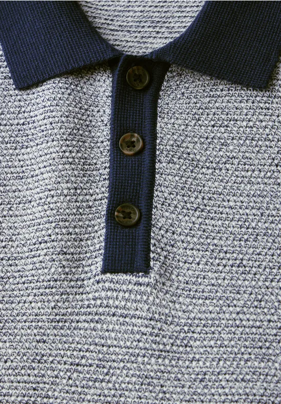 Nahaufnahme eines gestrickten Poloshirts mit drei Knöpfen und dunklem Kragen.