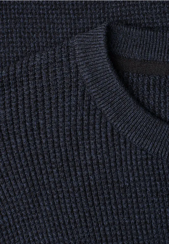 Close-up van een donkerblauw geribbelde trui met ronde hals.