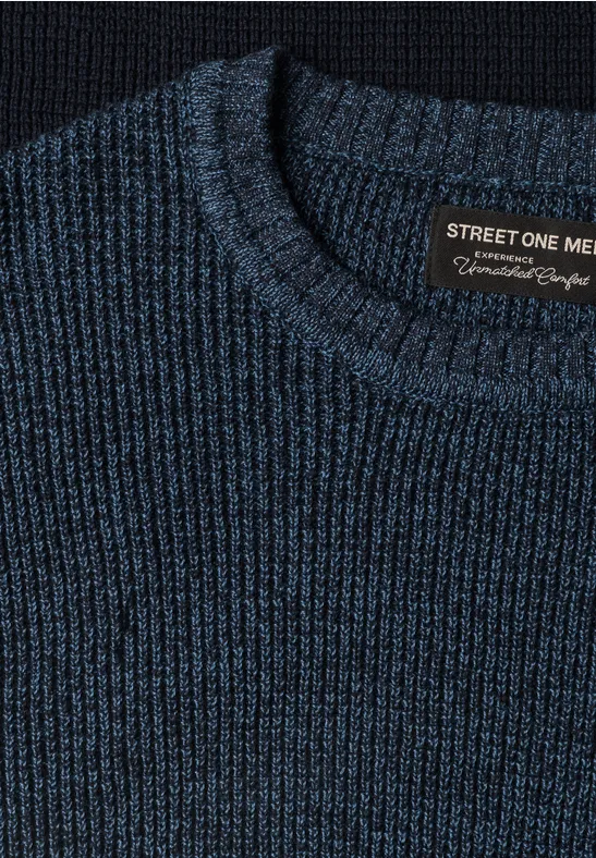 Close-up van donkerblauwe gebreide trui met ronde hals en 'Street One Men'-label op houten ondergrond.