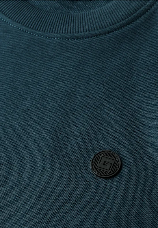 Ciemnozielony T-shirt z czarną, okrągłą łatką z logo na piersi.