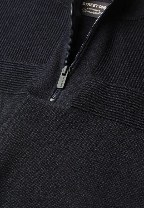 Schwarzer Strickpullover mit halbem Reißverschluss und markanter Rippstruktur am Ausschnitt.