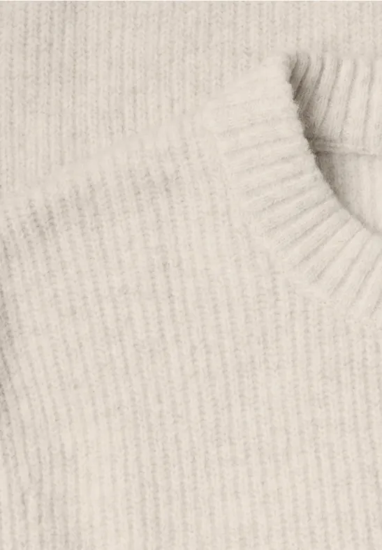 Close-up eines cremefarbenen, gerippten Strickpullovers