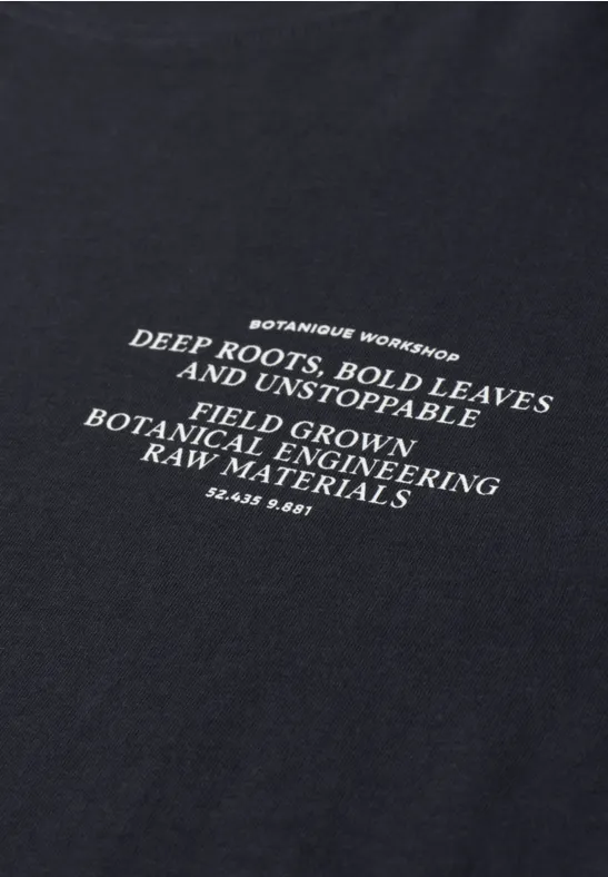 Schwarzes T-Shirt mit weißem Printtext über botanische Entwicklung und kräftiges Pflanzenwachstum.