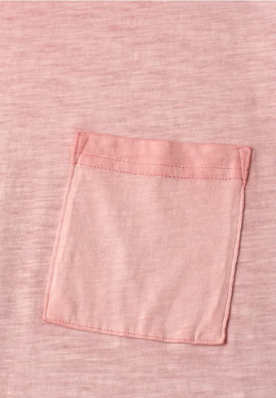 Rosa T-Shirt mit einer kleinen eckigen Brusttasche aus dem gleichen Stoff.