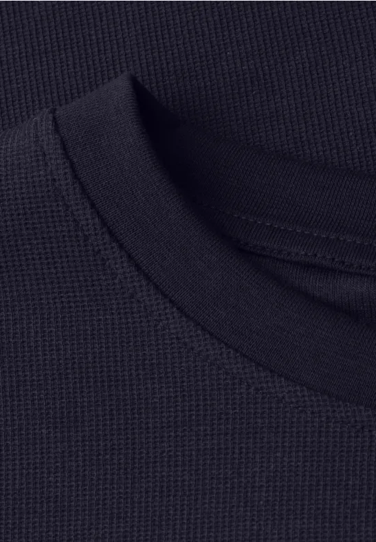Nahaufnahme eines schwarzen, feinmaschigen Rundhals-Shirt-Kragens