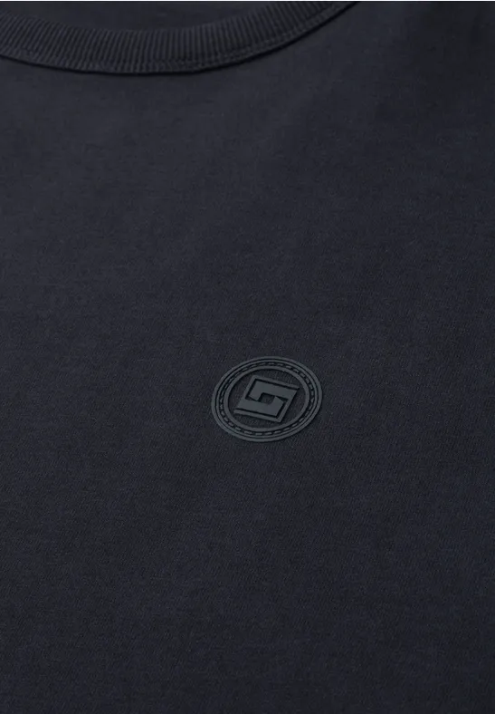 Schwarzes T-Shirt mit schlichtem, rundem Logoaufdruck auf der Brust.