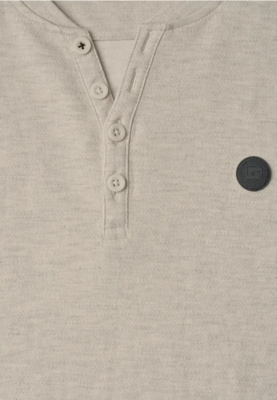 Beiges, strukturiertes Henley-Shirt mit Knopfleiste und kleinem, schwarzem Logo-Patch.