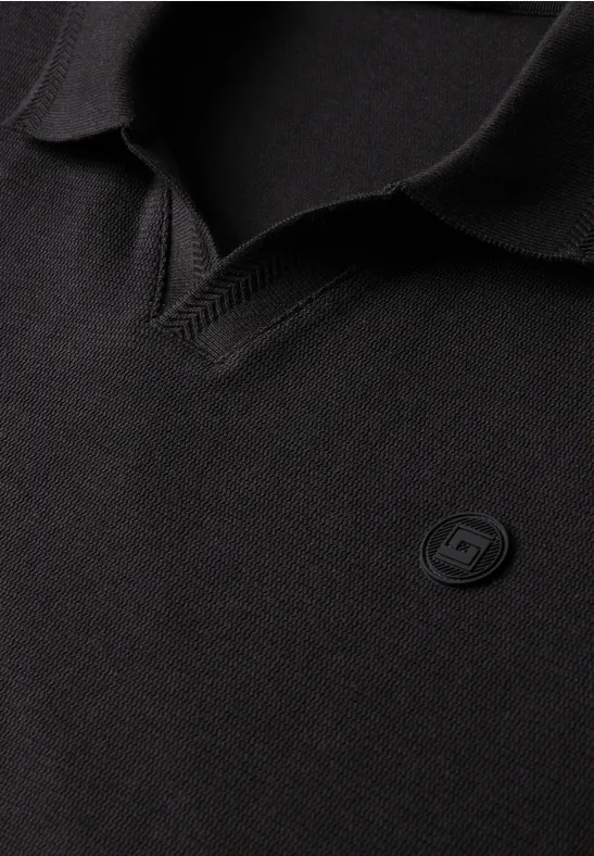 Zwarte poloshirt met V-halskraag en een subtiel rond logobadge op de borst.