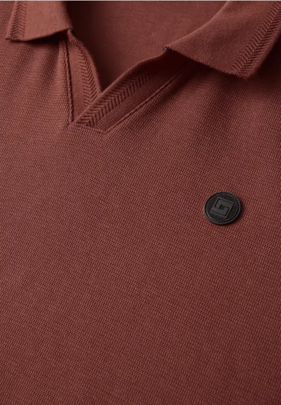 Bruine polo met V-hals en klein rond logo-embleem op de borst.