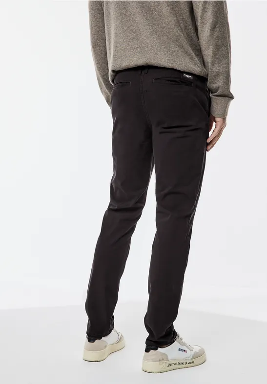 Person in dunkler Hose und Pullover, steht mit dem Rücken zur Kamera.