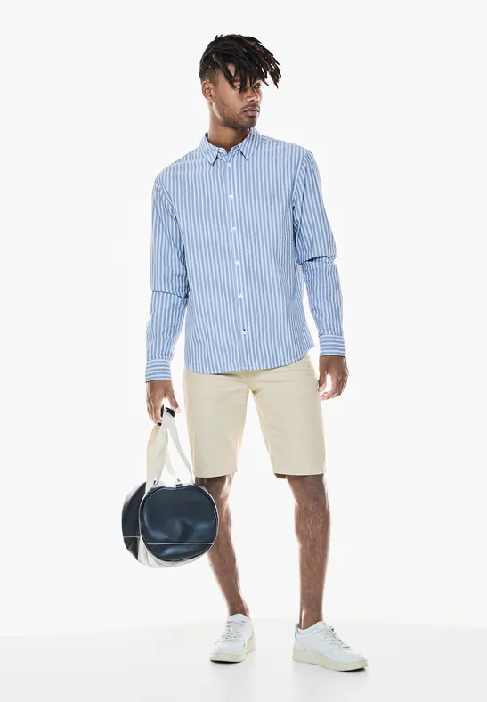 Mann mit gestreiftem Hemd, Shorts und Sporttasche.