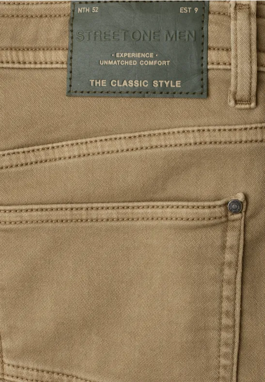 Beige Herrenhose mit sichtbarer Tasche, Label "The Classic Style" und kontrastierenden Nähten.