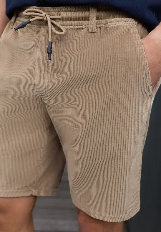 Man draagt beige corduroy short met trekkoord en zijzakken.