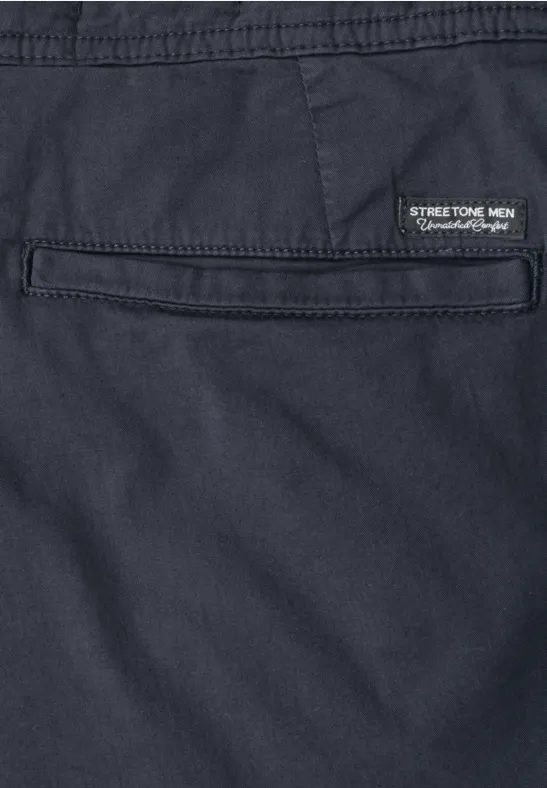 Nahaufnahme einer dunkelblauen Hose mit Gesäßtasche und kleinem Label 'STREET-TECH MEN Performance Wear'.