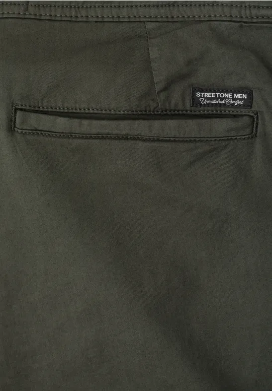Detail van een olijfgroene broek met achterzak en Stretch-label.
