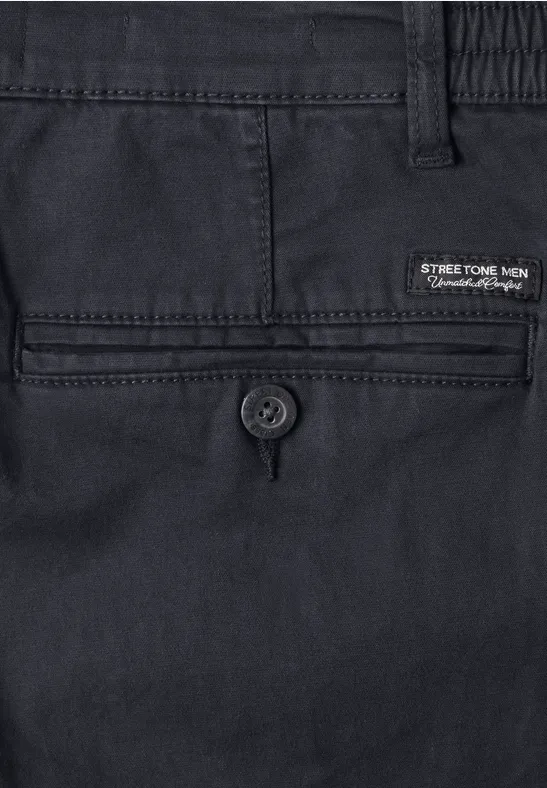 Nahaufnahme einer dunkelblauen Herrenhose, Rücktasche mit Knopfverschluss und Markenlabel.