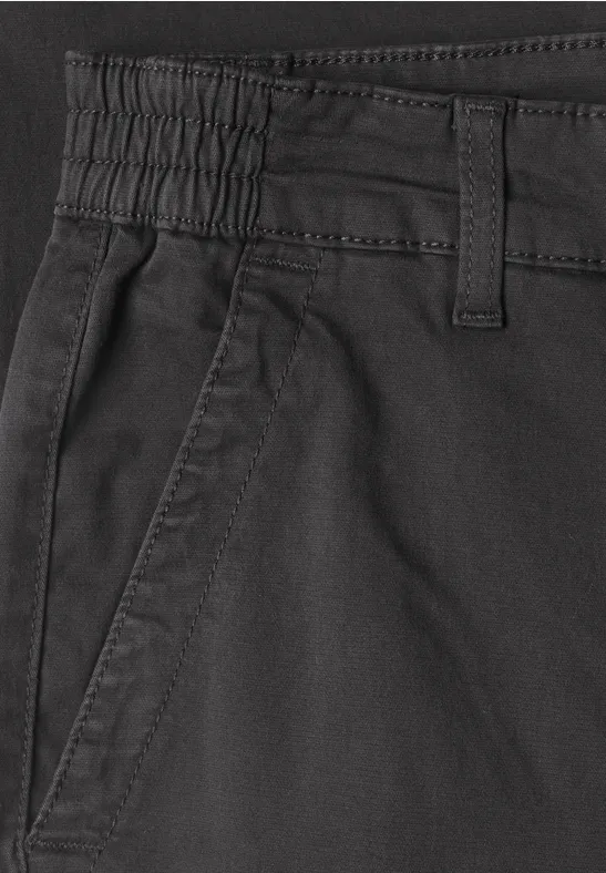 Nahe Ansicht einer schwarzen Hose mit Gummizug, Gürtelschlaufen und seitlicher Tasche.
