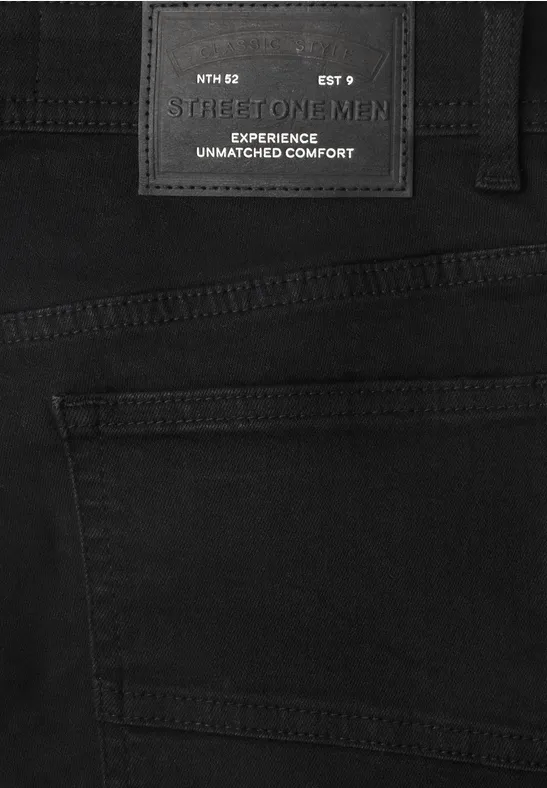 Schwarze Jeanshose mit schwarzem Label 'FOR MEN' und Text 'EXPERIENCE UNMATCHED COMFORT'.