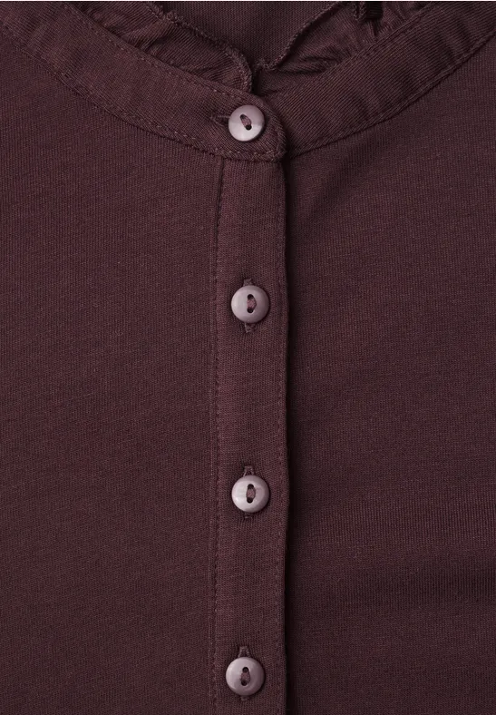 Bordeauxfarbener Cardigan mit Rüschenkragen und vier runden Knöpfen.