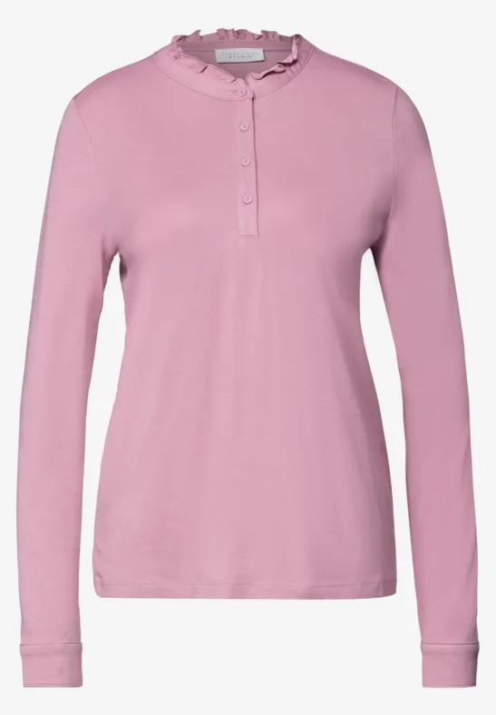 Rosa Langarmshirt mit Rüschenkragen und Knopfleiste, schlicht und elegant.