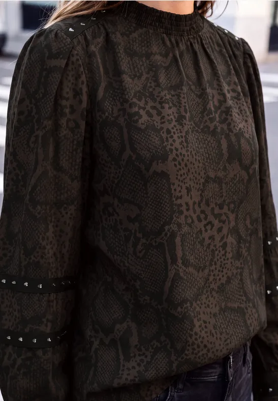 Schwarz-braune Bluse mit Schlangenmuster, hohem Kragen und feinen Lochstickereien an den Ärmeln.