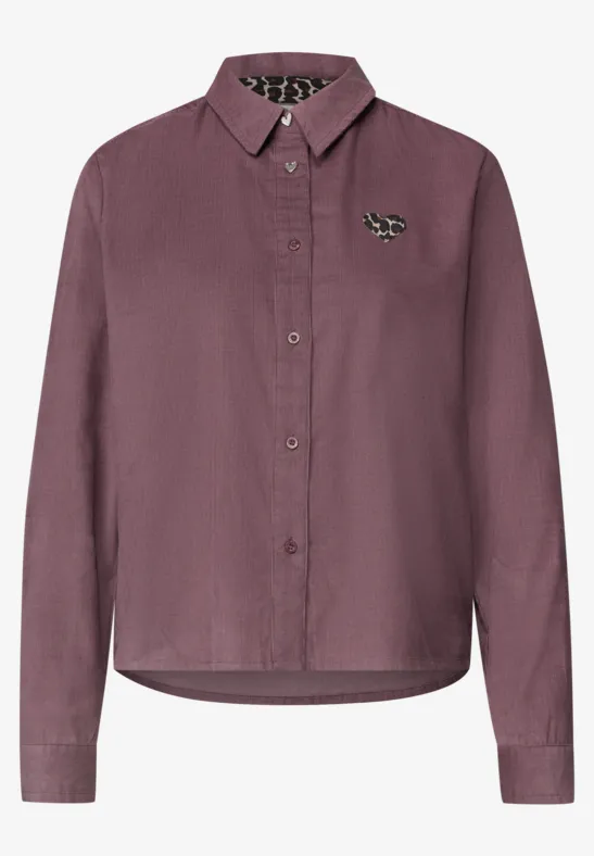Dunkelviolette Bluse mit Kragen, langen Ärmeln, Knopfleiste und dekorativem Broschen-Anstecker.