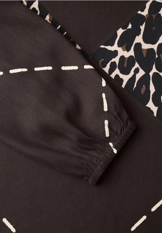 Dunkles Oberteil mit weißen Naht-Prints und Leopardenmuster