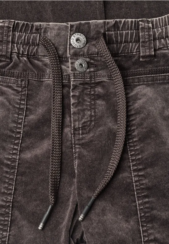 Schwarze Cordhose mit Kordelzug, Bundfalten und Knopfverschluss.