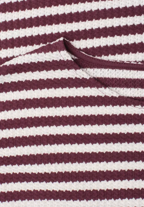 Rote und weiße horizontale Streifen, eng gestrickt, mit aufgesetzter Tasche.