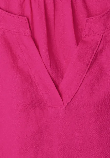 Magenta-farbener Stoff mit V-förmigem Ausschnitt und dezenten Nähten.