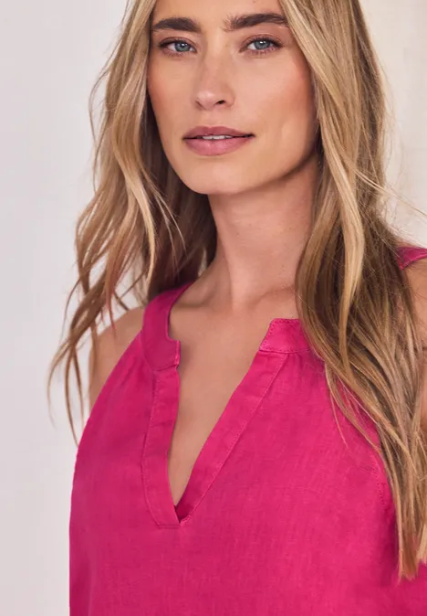 Eine Frau trägt ein ärmelloses pinkes Top mit V-Ausschnitt.