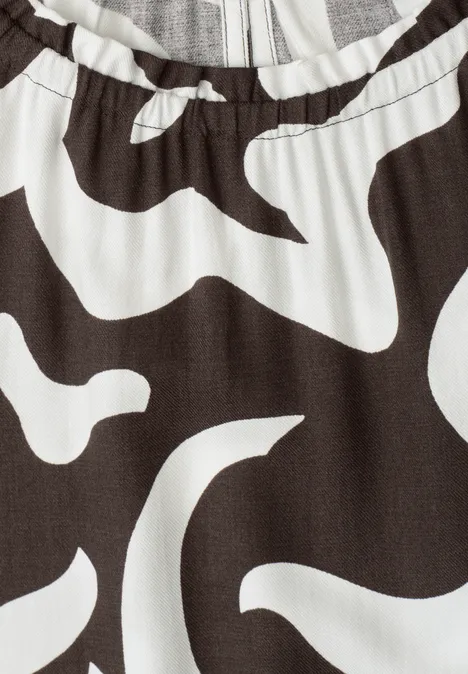 Nahansicht eines Kleidungsstücks mit elastischem Bund und abstraktem Schwarz-Weiß-Muster.