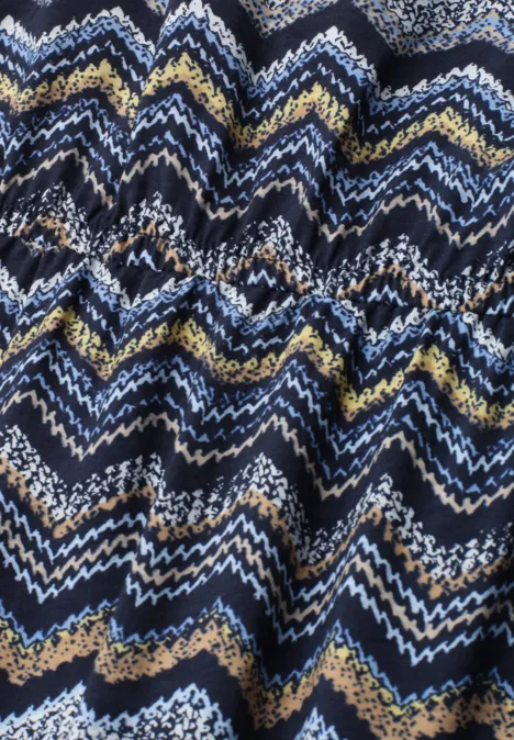Nahaufnahme eines gestrickten Zigzag-Musters in Marineblau, Weiß, Gelb und Beige.